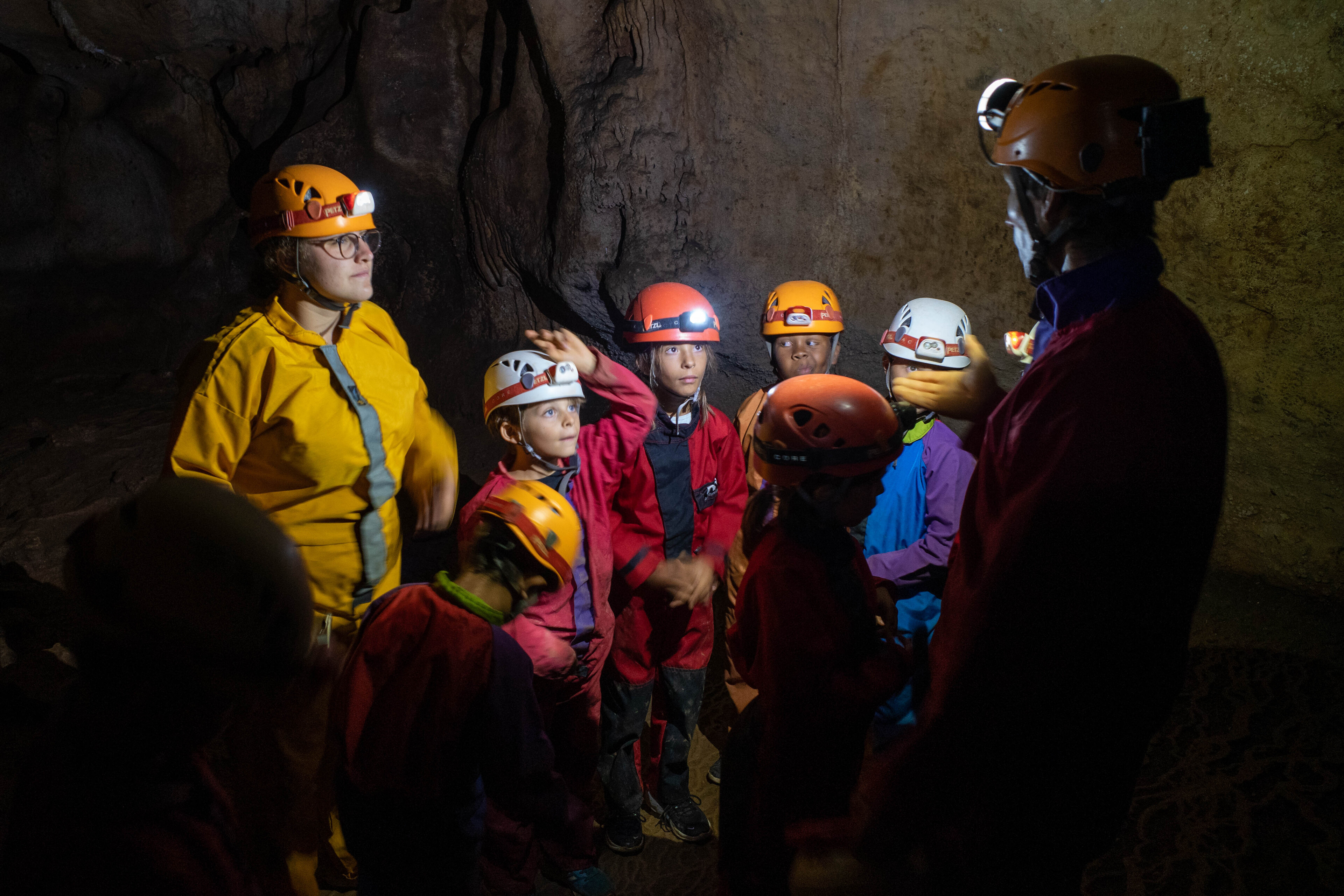 Activité scolaire sport nature : la spéléolgie Photo de l'activité scolaire sport nature : la spéléologie, montrant un groupe d'enfant dans une salle sombre au cœur de la grotte